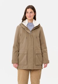 Giacca impermeabile color sabbia con cappuccio foderato in pelliccia, zip frontale e due grandi tasche. Presenta un cordino in vita per una regolazione ottimale.