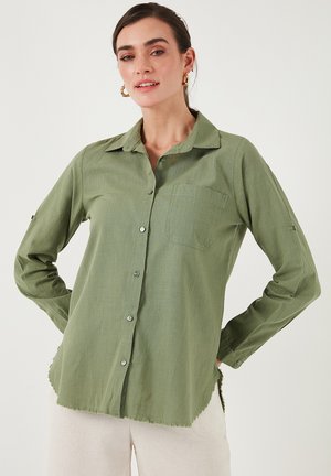 Green long-sleeve shirt in lightweight fabric, featuring a button-down front, a single chest pocket, and frayed hem details.