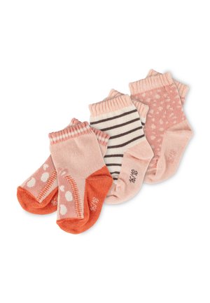 Vier Paar pinke und orangefarbene Babysocken mit verschiedenen Mustern, darunter Streifen, Punkte und einfarbige Zehen, nebeneinander angeordnet.