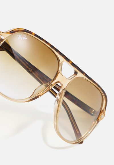 Слънчеви очила Ray-Ban с прозрачно кафяво рамка, кафяви градиентни стъкла и отличителен акцент от черупка на храмовете.