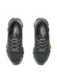 Scarpe da ginnastica nere con tomaia in rete, dettagli arancioni, lacci e colletto imbottito, dotate di suola tondeggiante per ammortizzazione e supporto.