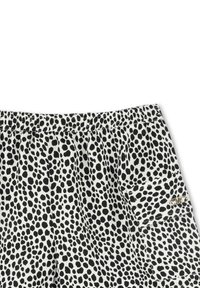 Zwart-witte shorts met een vlekkenpatroon, voorzien van een elastische tailleband en een zijzak met hardware-detail.