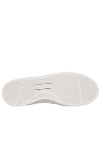 Suola di sneaker Skechers in beige chiaro, caratterizzata da una superficie in gomma testurizzata con scanalature orizzontali e verticali e nome del marchio impresso.