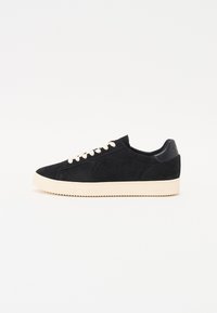Sneaker in suede nero con suola in gomma crema e lacci a contrasto bianco sporco. Design minimal con colletto imbottito e logo sul tallone.