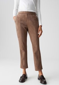 Pantaloni cropped in finta suede marrone con una texture liscia e una vestibilità sartoriale, dotati di un alto punto vita e tasche laterali.
