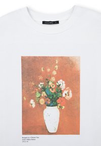 T-shirt bianco con una stampa di un dipinto di fiori colorati in un vaso bianco su uno sfondo arancione tenue, intitolato "Bouquet in a Chinese Vase."