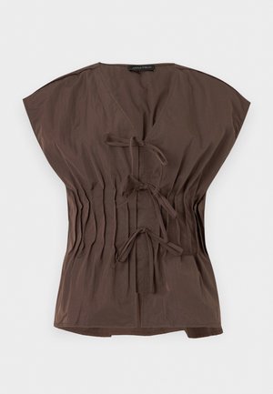 Blouse marron à manches courtes avec col en V, comportant trois liens à nouer à l'avant et des côtés élastiqués froncés pour une taille cintrée.