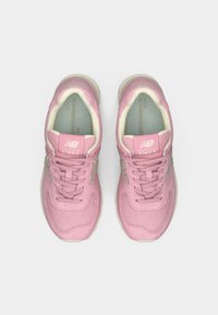 Adidași New Balance roz cu un brâu texturat, design cu șireturi și un interior moale și căptușit. Prezintă o talpă de culoare deschisă și accente cu logo.