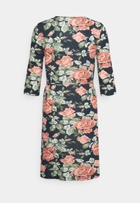 Vestido floral com fundo azul-marinho, grandes rosas cor-de-rosa e folhas verdes. Mangas longas e detalhe na cintura. Textura de tecido suave.