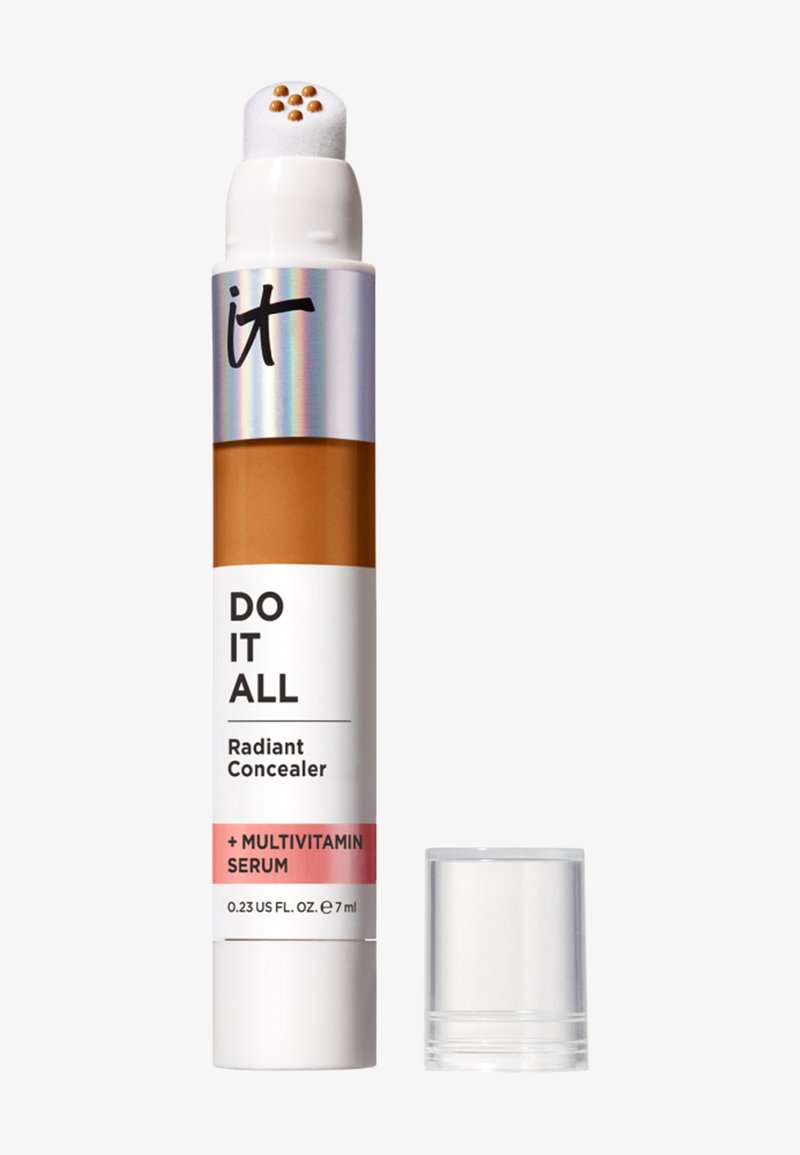 Bâton correcteur avec applicateur en éponge montrant de petites gouttes de produit, étiqueté "Do It All Radiant Concealer + Multivitamin Serum".