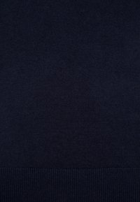 Mörkblå stickad tröja med en mjuk textur, ribbat avslut och en klassisk design utan ytterligare mönster eller detaljer.