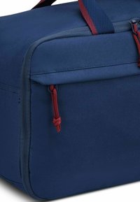 Borsa di stoffa blu dalla forma rettangolare, con una zip rossa e un gancio, superficie testurizzata e cuciture rinforzate lungo i bordi.
