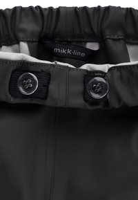 Schwarze wasserdichte Jacke mit elastischem Kragen, ausgestattet mit grauem Innenfutter und schwarzen Verschlüssen. Das Etikett trägt die Aufschrift "mikk-line."