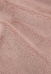 Blødt pink fleece-stof med en tekstureret overflade, der har fine, fluffy fibre og subtil dybde fra overlappende lag.