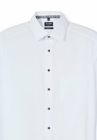 Weißes Hemd mit modernem Schnitt, ausgestattet mit einem klassischen Kragen, braunen Knöpfen und einer Tasche auf der linken Seite. Detailreiche, strukturierte Stoffqualität.