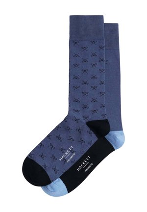 Chaussettes bleu marine et bleu clair avec un motif de ciseaux. Une chaussette est de couleur bleu marine uni avec des accents noirs ; l'autre présente un revers bleu clair.