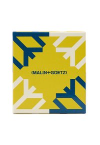 Quadratische Verpackung mit lebhaftem gelbem Hintergrund und blauen sowie weißen geometrischen Mustern. Auf der Vorderseite steht der Text „(MALIN+GOETZ)“.