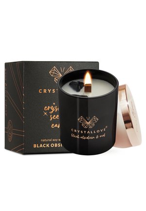 Black ceramic candle with a wooden wick, lit, featuring a gold lid. Box displays black and gold design with text: "CRYSTALLOVE, black obsidian & oud."