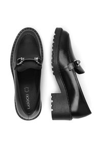 Czarne skórzane buty z okrągłym noskiem, ozdobnymi srebrnymi klamrami, masywną teksturowaną podeszwą i kontrastującymi przeszyciami wzdłuż krawędzi.