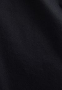 Juoda medžiaga su lygiu paviršiumi ir įstrižainiu audimo raštu, demonstruojanti vienodą spalvą ir subtilų blizgesį, puikiai tinkanti įvairiems panaudojimams.