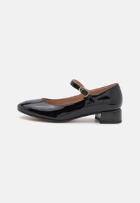 Chaussures Mary Jane en cuir verni noir avec un bout arrondi, un petit talon carré et une bride ajustable avec un détail en boucle dorée.