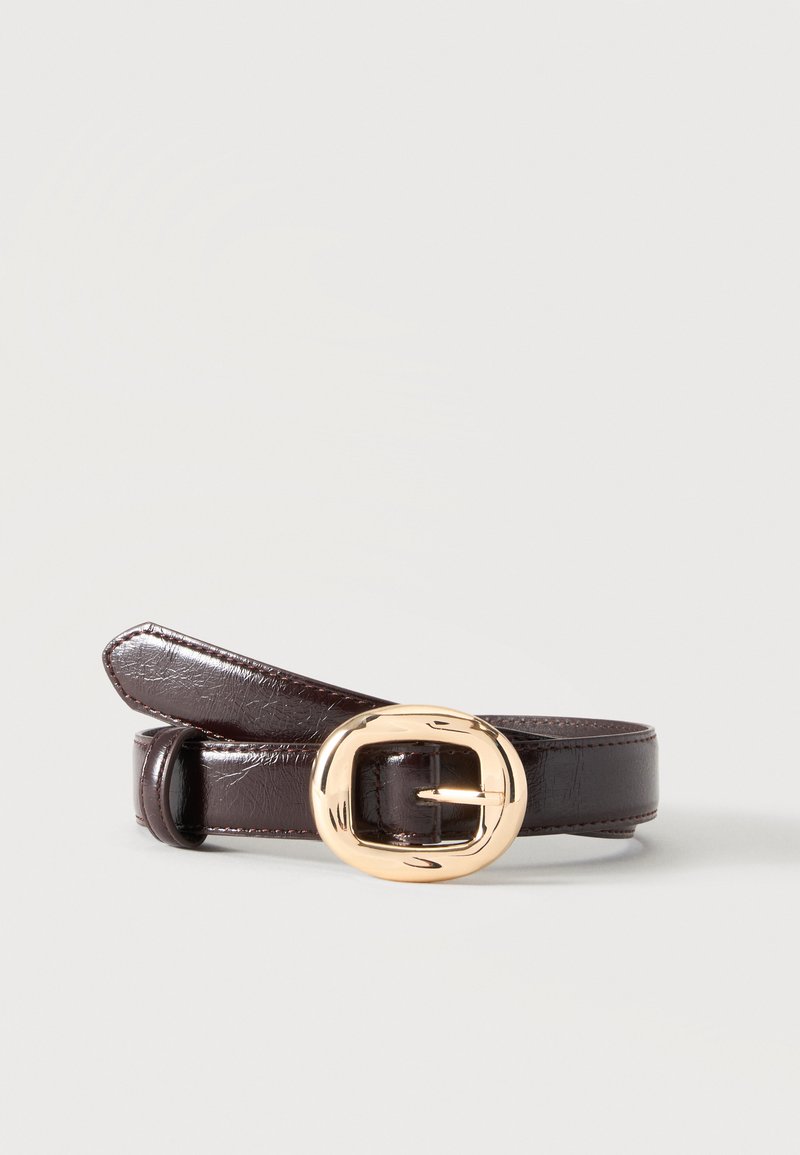 Ceinture en cuir brun foncé enroulée avec une boucle rectangulaire arrondie dorée et brillante sur un fond uni clair.