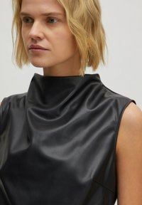 Zwarte mouwloze top van gladde, glanzende stof met een hoge kraag en subtiele draperingen, met een strakke silhouet en minimale naden.