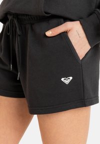 Čierne bavlnené šortky s elastickým pásom a šnúrkou, s bočnými vreckami a bielym logom na leme.