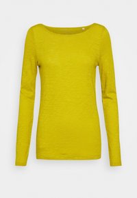 Maglietta da donna a maniche lunghe gialla con scollatura tonda, taglio slim e un sottile motivo di tessuto a trama su sfondo bianco.