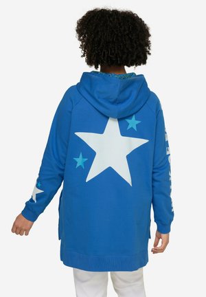 Felpa con cappuccio blu che presenta una grande stella bianca sul retro, stelle più piccole blu e testo sulle maniche. Il materiale sembra morbido, con una vestibilità comoda.