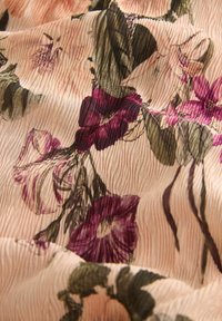 Blumenstoff mit rosa, lila und grünen botanischen Druckmotiven auf einem strukturierten Hintergrund mit gefältelten Linien. Weiches und leichtes Material.