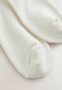 Valged puuvillased sokid ribatud tekstuuriga, ümardatud varbaga ja siledast viimistlusest. Lihtne disain, sobib igapäevaseks kandmiseks.