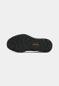 Schwarze Gummisohle mit robustem Profildesign und kleinem orangefarbenen Continental-Logo in der Mitte, isoliert auf weißem Hintergrund.