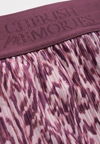 Tessuto viola con una cintura testurizzata caratterizzata dal testo in rilievo "CHERISH MEMORIES". La sezione inferiore plissettata mostra un motivo astratto rosa e viola.