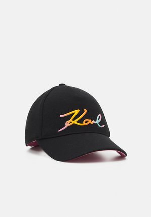 Casquette de baseball noire avec une visière incurvée, avec un logo manuscrit multicolore "Karl" à l'avant et une doublure rose sous la visière.