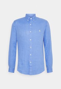 Light blue long-sleeve button-up shirt made of linen, featuring a classic collar, white buttons, and a small yellow logo on the chest.