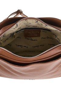 Borsa a tracolla in pelle marrone con chiusura a zip. L'interno presenta una fodera beige con un motivo di testo ripetuto e un'etichetta. Sono visibili più scomparti.