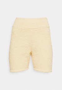 Yellow terry cloth shorts with a stretchy waistband. Features a simple design and short length. Includes a small logo detail on the leg.