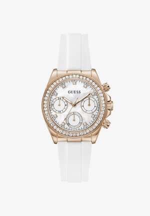 Ρολόι Guess με λευκό λουράκι σιλικόνης, κάσα σε ροζ χρυσό, στεφάνι με κρύσταλλα, λευκό καντράν, τρεις υποκαντράν και δείκτες ώρας με κρύσταλλα.