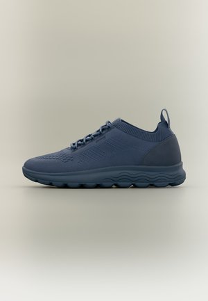 Mørkeblå strikket sneakers med tyk polstret sål, snørelukning foran og trækstrop bagpå, vist i sideprofil på neutral baggrund.