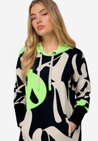 Hoodie met een gedurfde abstracte ontwerp in marineblauw, creme en neon groen, met een kangoeroezak en contrasterende afwerking.