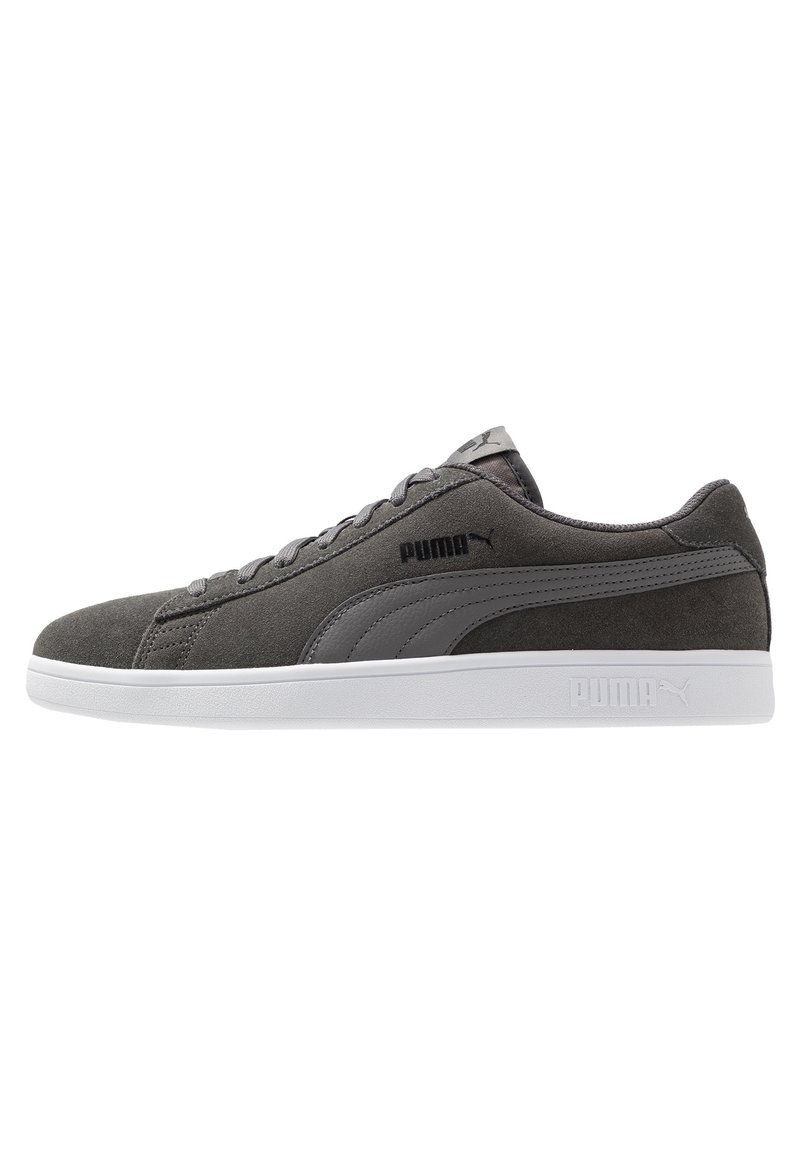 Sneaker in suede grigio con una suola in gomma bianca e dettagli grigio scuro. Presentano un design con lacci e un logo laterale. Texture liscia nel complesso.