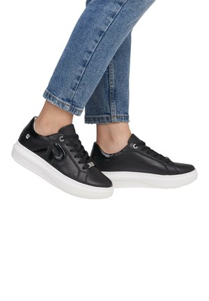 Baskets en cuir noir avec une finition lisse, semelle en caoutchouc blanche et bout arrondi. Dispose de lacets noirs et d'accents brillants. Pantalon en denim cropped visible.