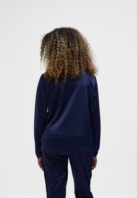 Marinblå tröja med lång ärm tillverkad av mjukt, lätt tyg. Har en avslappnad passform och enkel design utan synliga mönster eller detaljer.