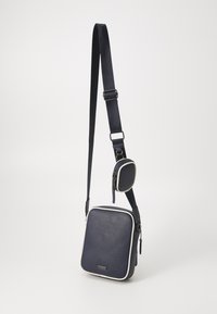 Borsa a tracolla blu in materiale testurizzato, con forma quadrata, dettagli bianchi, tracolla regolabile e una piccola pochette attaccata con zip.