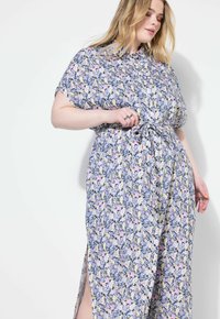 Abito maxi floreale blu con maniche corte, caratterizzato da una vita annodata, spacchi laterali e un motivo di fiori multicolore su tutta la superficie.