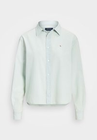 Ljusgrön långärmad skjorta med knäppning framtill, krage och en liten broderad logotyp på bröstet. Tillverkad av bomull med en smidig textur.