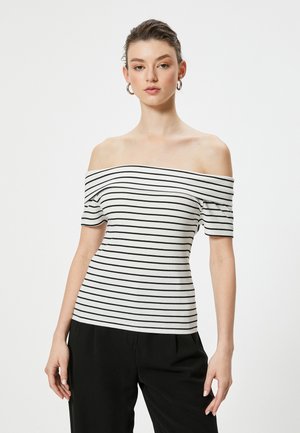 Top off-the-shoulder con texture a coste, con strisce orizzontali nere su sfondo bianco. Maniche corte, design aderente.