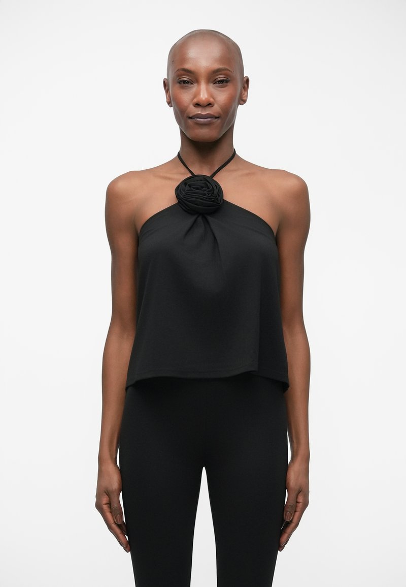 Černý halter top s květinovým detailem na výstřihu, vyrobený z měkké tkaniny, s volným a splývavým střihem.
