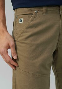 Khakifarbene Cargo-Hosen mit geradem Bein, ausgestattet mit einer Reißverschluss-Tasche, verstärkten Nähten und einem Logo-Patch am Bund. Aus weichem Baumwollmaterial.